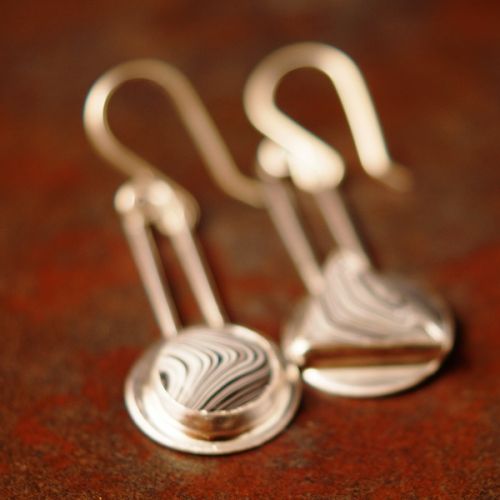 Handcrafted sterling silver bezel set asymmetric round and triangular Fordite earrings 