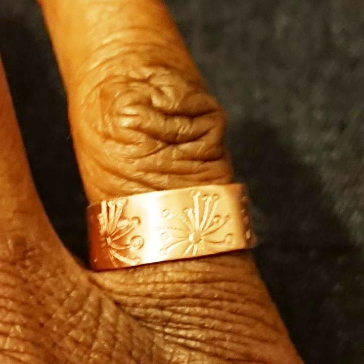 Handmade dandelion stamped copper ring on right hand little finger