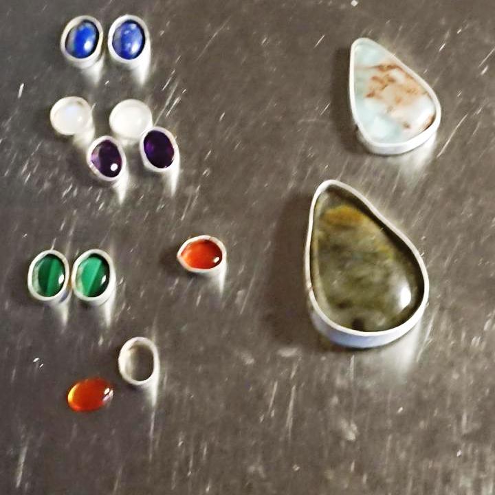Assortment of healing crystal cabochons on my jewellery bench ready for bezel setting
